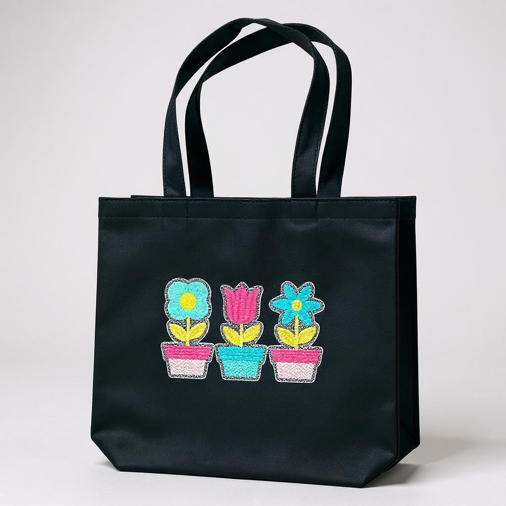 Black tote bag with floral designs on a white background
